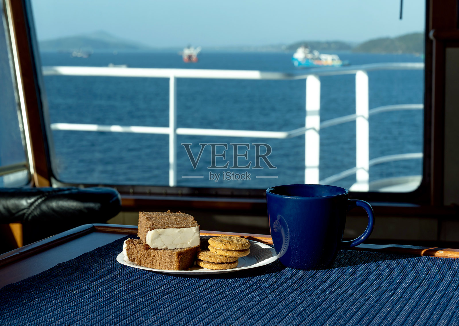 桌子上放着一杯咖啡和几块饼干。照片摄影图片