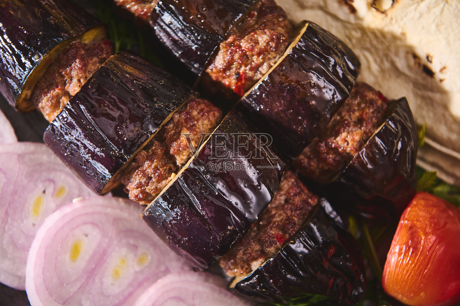 烤茄子和肉串配洋葱片及番茄，呈现出一道传统中东美食，味道丰富而美味。照片摄影图片