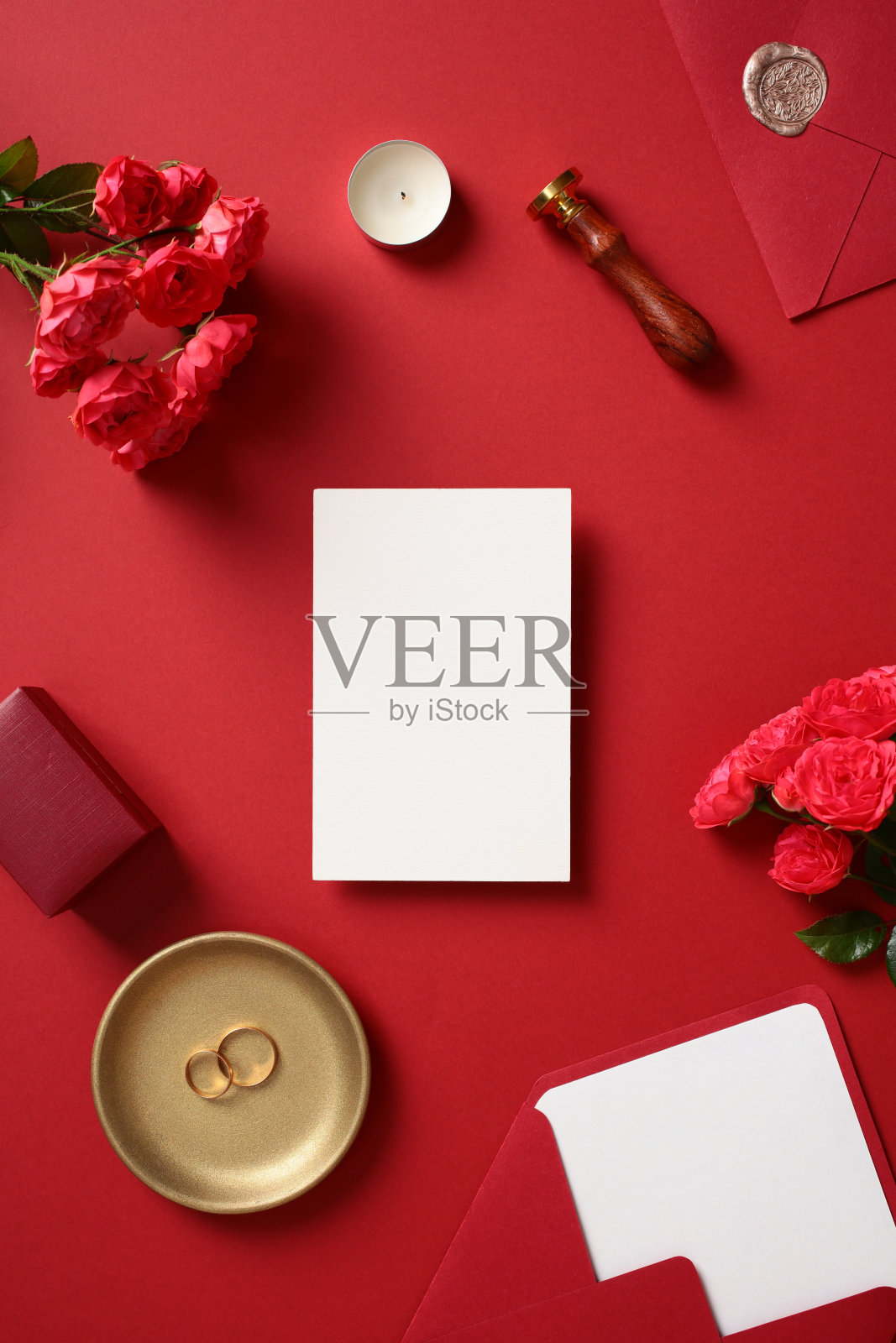 红色背景上的婚礼空白纸质请柬卡片与文具。平铺视角，顶部视图，留白空间。照片摄影图片