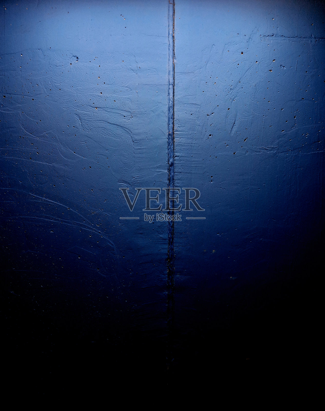 一个由粗加工混凝土制成的地下车库或入口大厅。现代的蓝色涂装从天花板上照亮。聚光灯。照片摄影图片