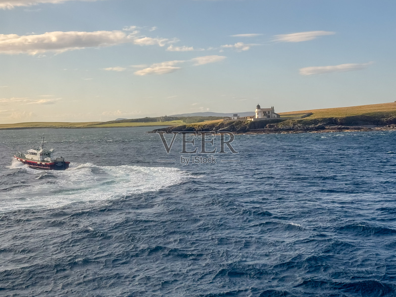 一艘引航船在苏格兰奥克尼岛基尔科尔镇沿海为一艘游轮离港。照片摄影图片