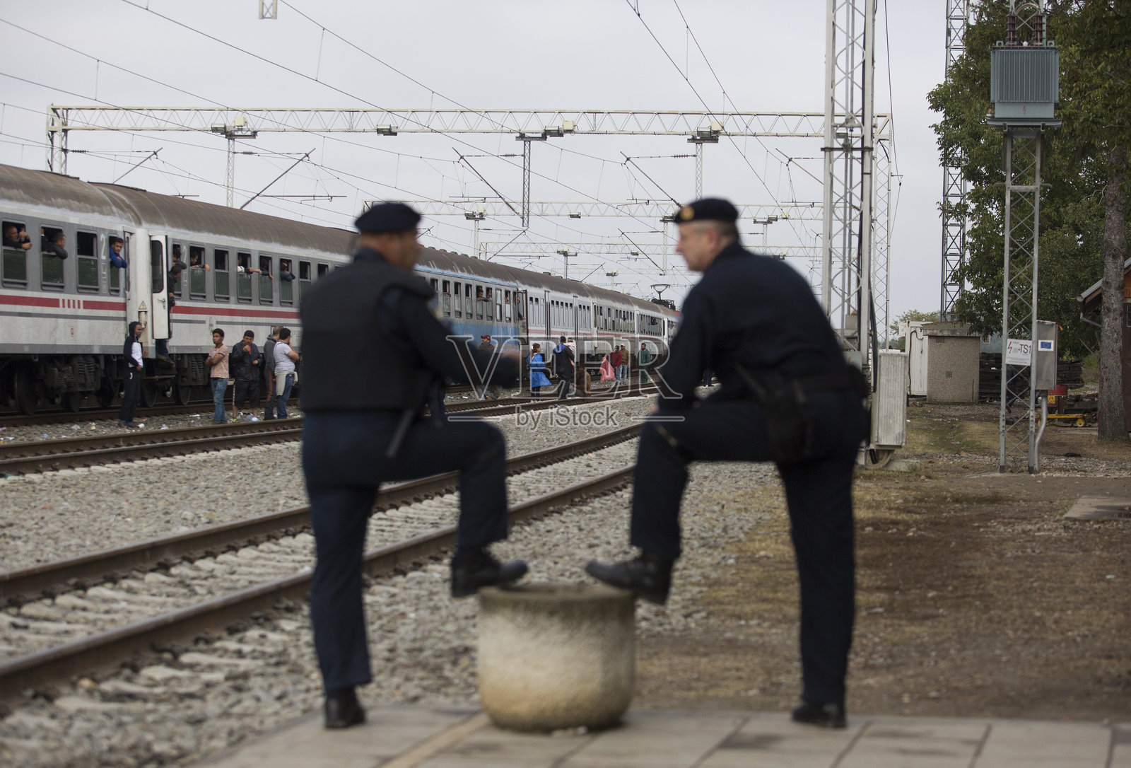 克罗地亚警察和叙利亚难民。照片摄影图片