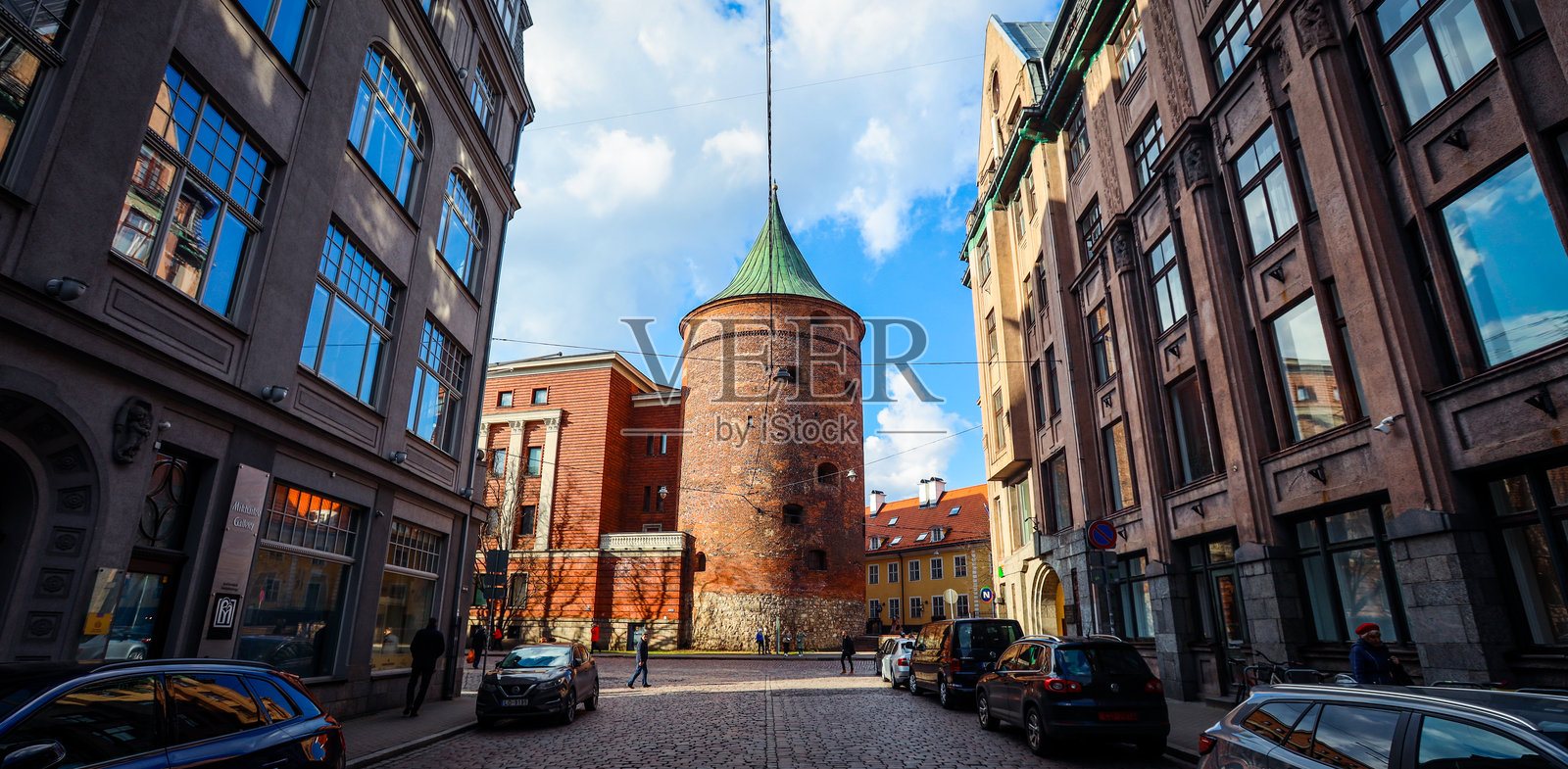 里加老城的历史建筑与现代建筑在阳光明媚的日子里交汇，展现出一座中世纪塔楼。照片摄影图片