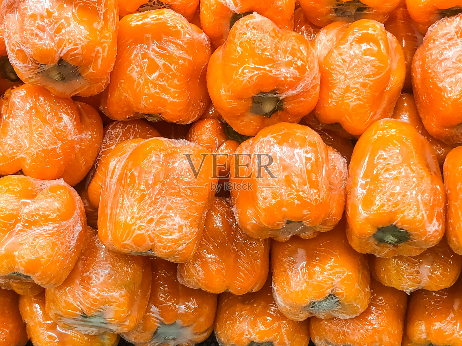 新鲜的橙色甜椒用塑料包装着照片摄影图片