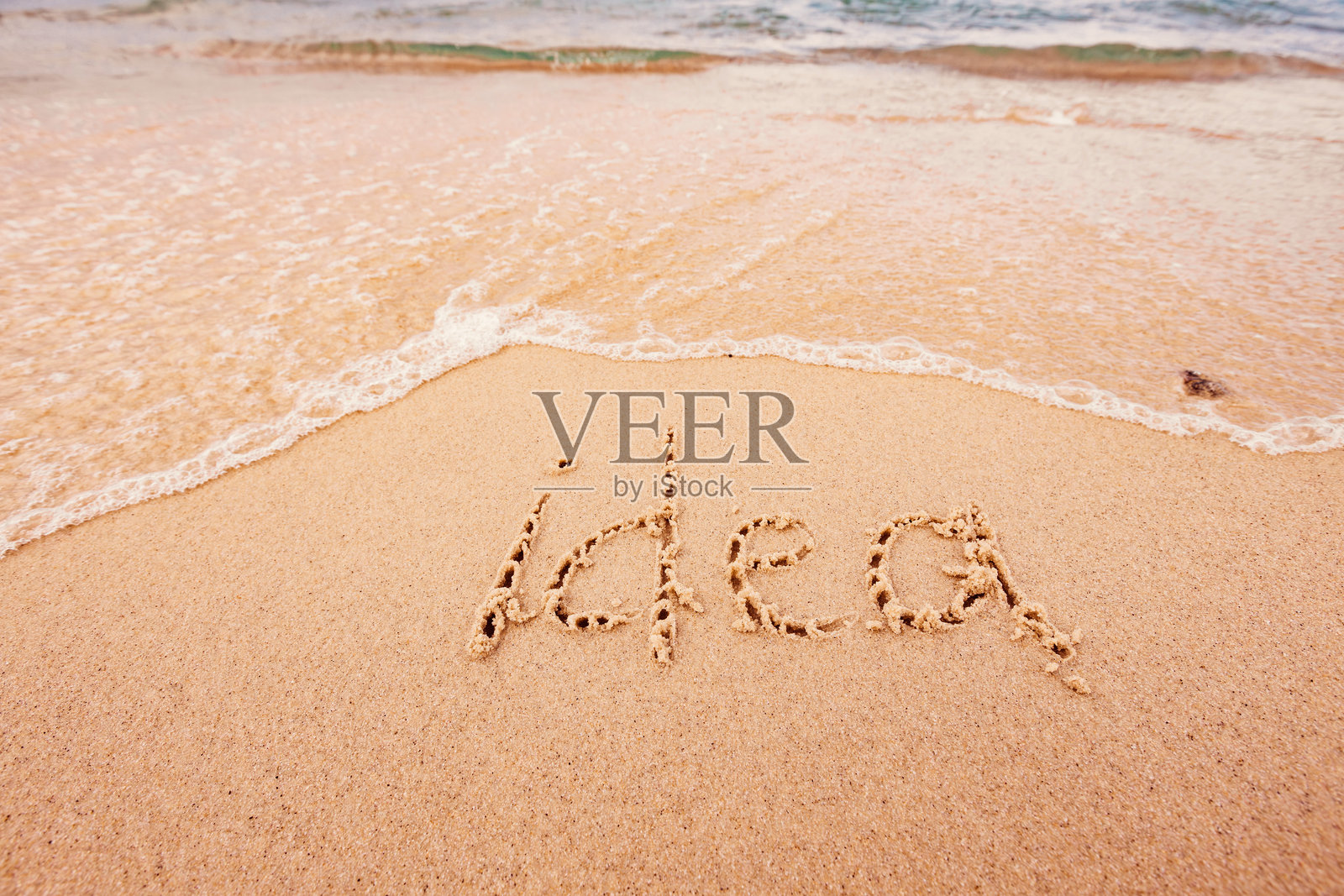 海滩上的“理念”字样与棕榈树照片摄影图片