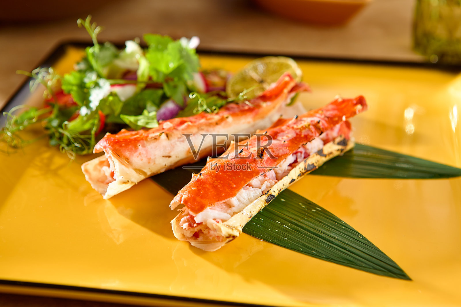 鲜艳的海鲜盛宴搭配新鲜沙拉，盛放在黄色盘子上照片摄影图片