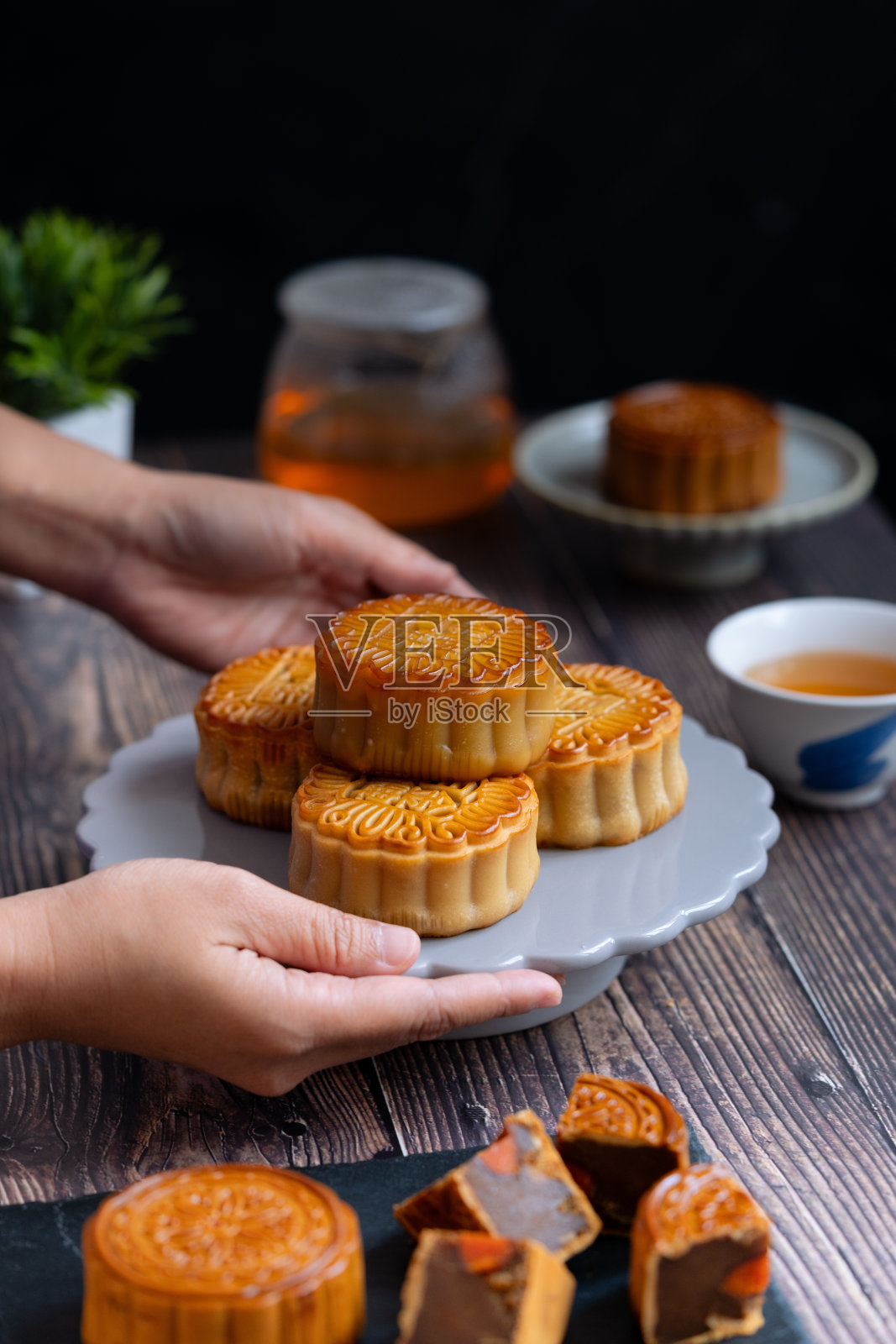 一盘中国月饼，手正准备端上来。照片摄影图片