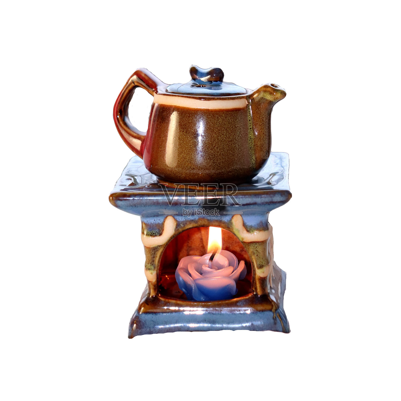 带有燃烧蜡烛的陶瓷茶壶烛台 - 彩色照片，适合设计使用。照片摄影图片