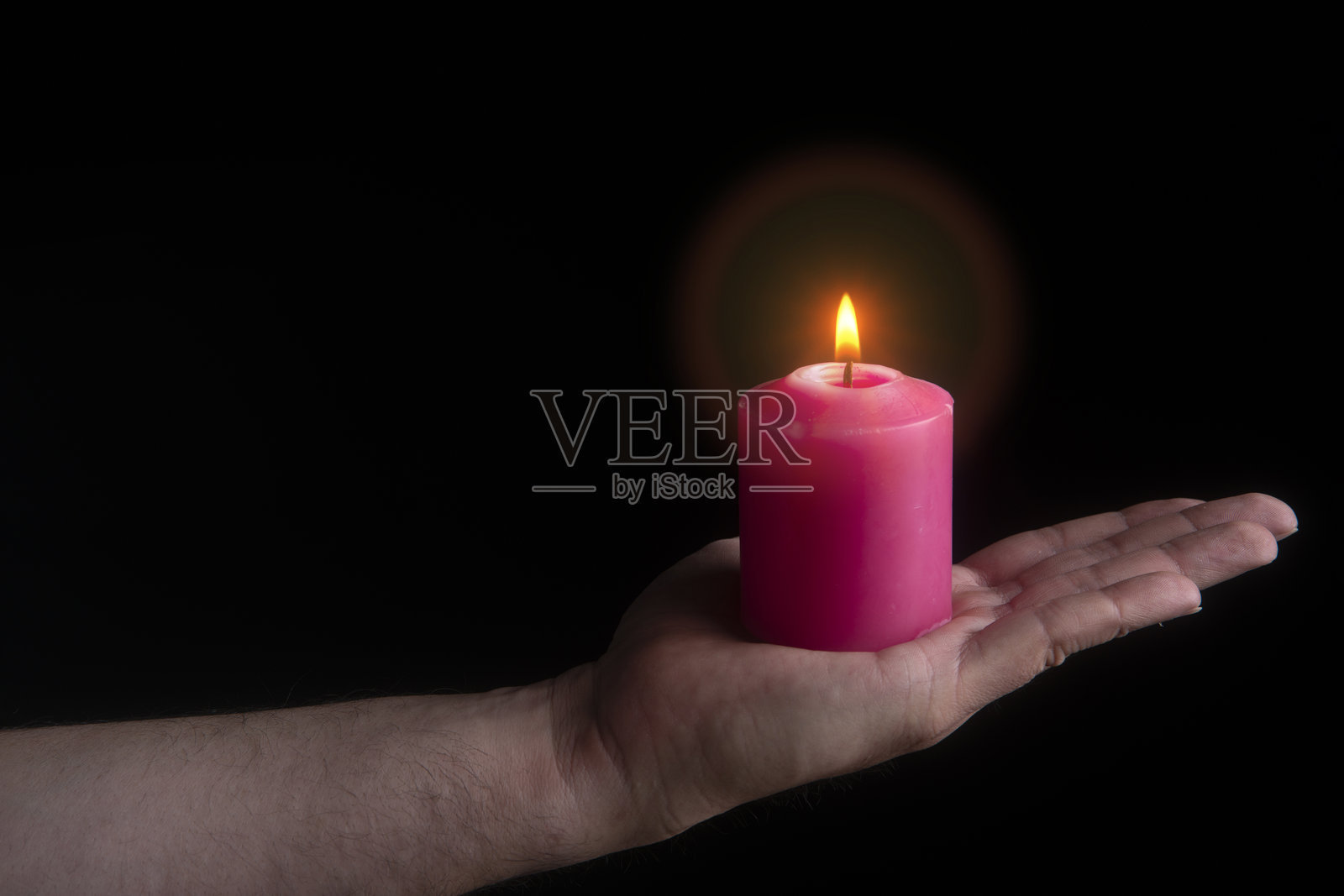 男人伸出的手拿着点燃的红色蜡烛照片摄影图片