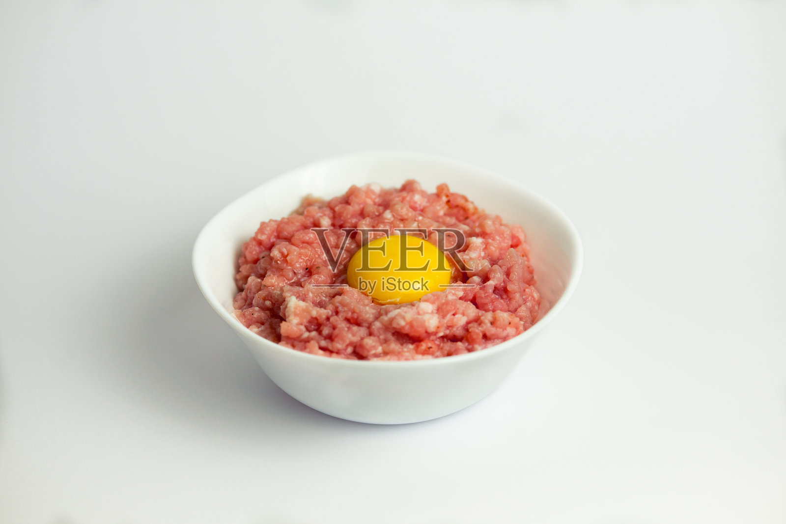 白碗里的肉末和生鸡蛋照片摄影图片