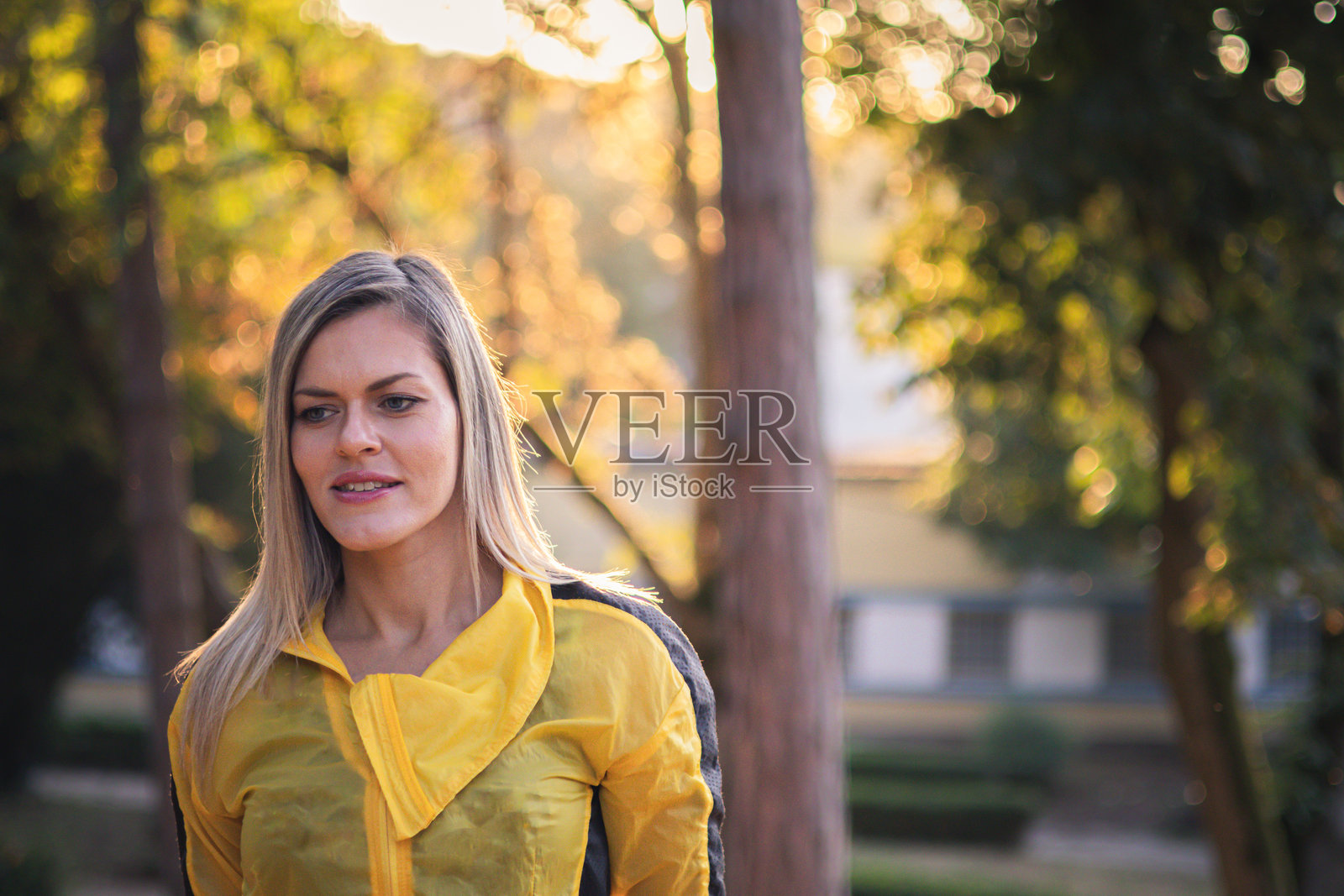 在秋天与自然亲密接触。快乐、微笑的金发女性在日落时分重新与自然连接。照片摄影图片