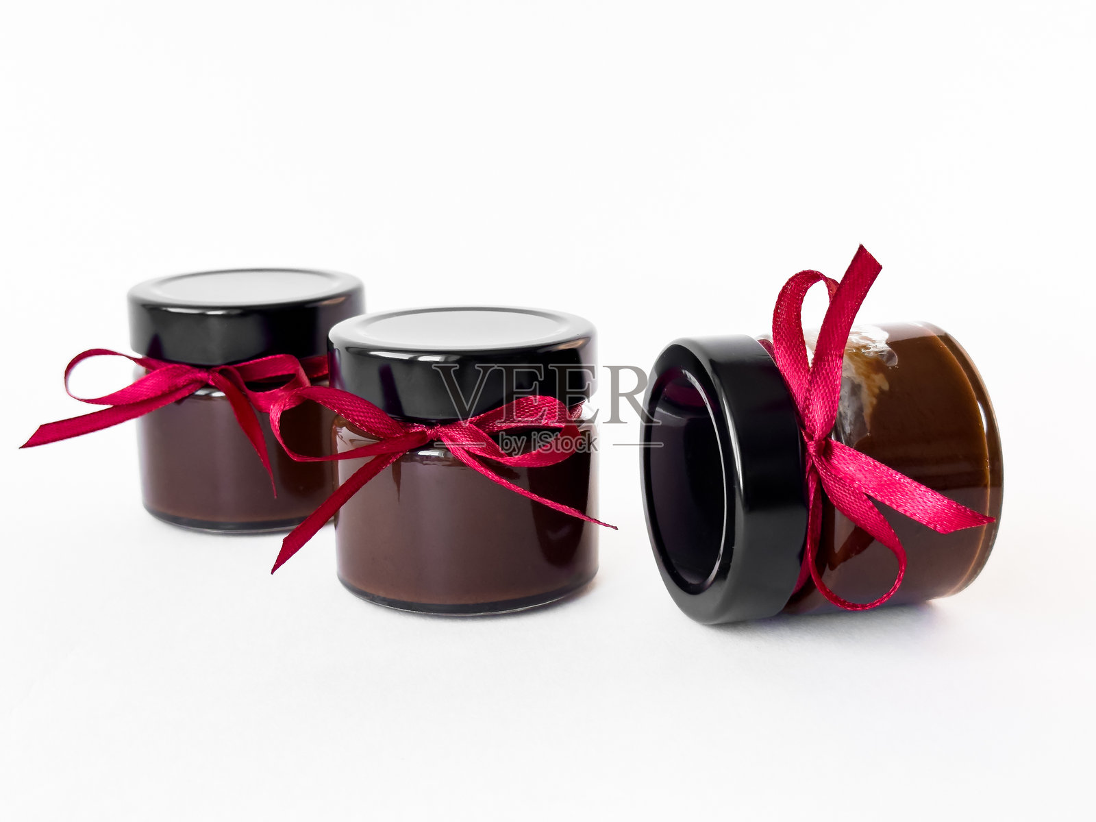 优雅的黑色玻璃罐，配有红色丝带，背景为白色照片摄影图片