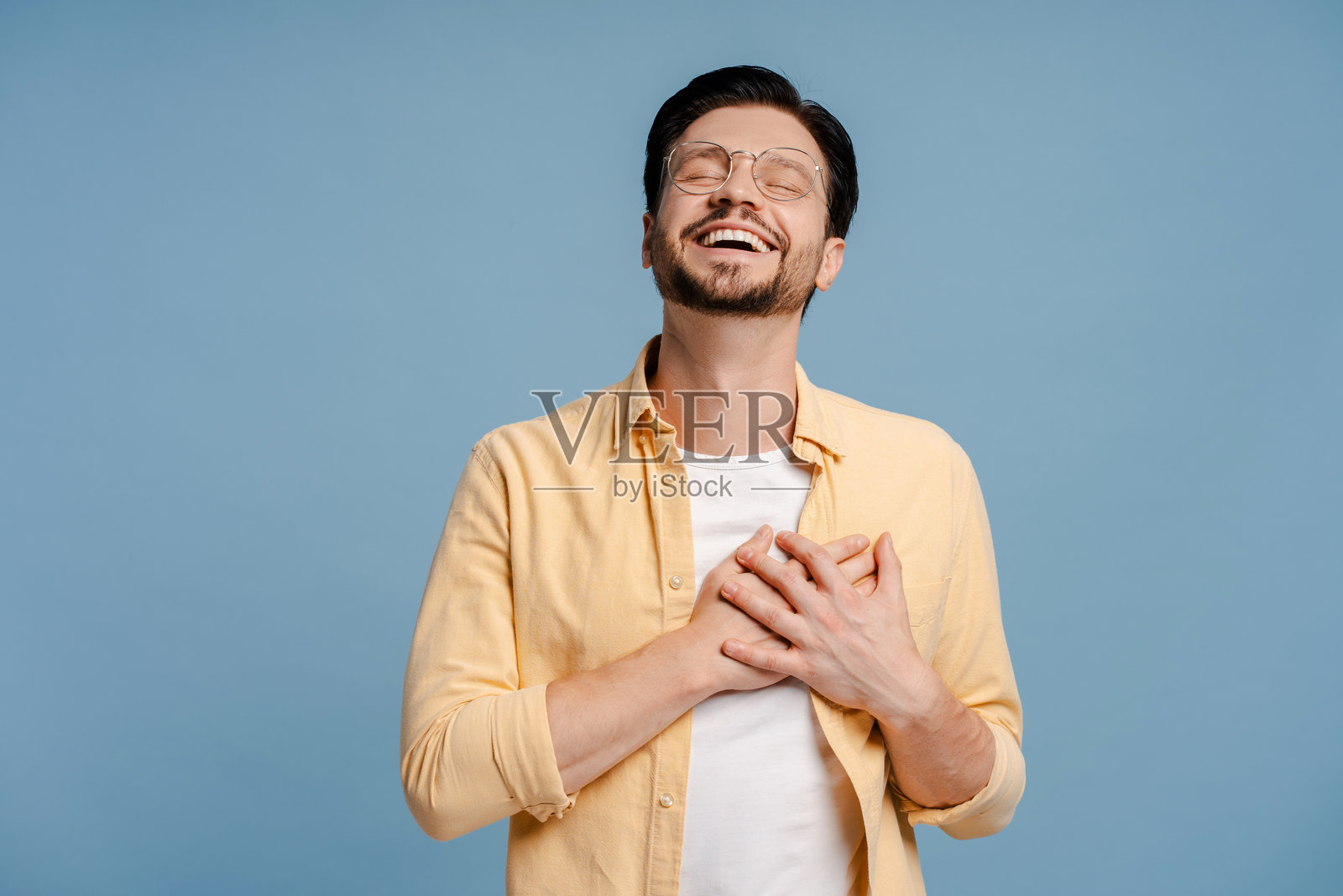 男子双手放在胸前，闭着眼睛，心怀感激照片摄影图片