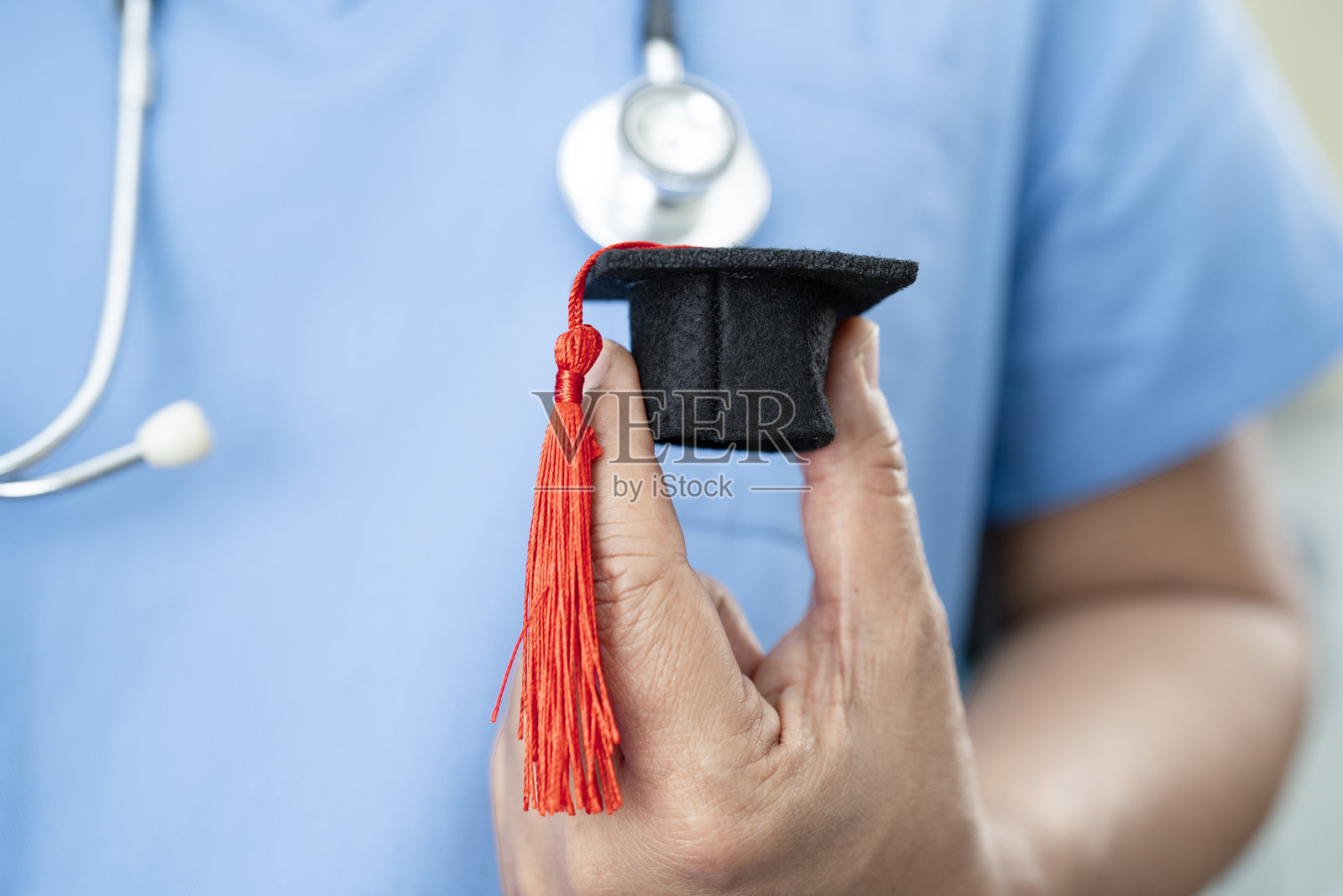 亚洲女性医生在医院里手持红色心脏，象征健康。照片摄影图片