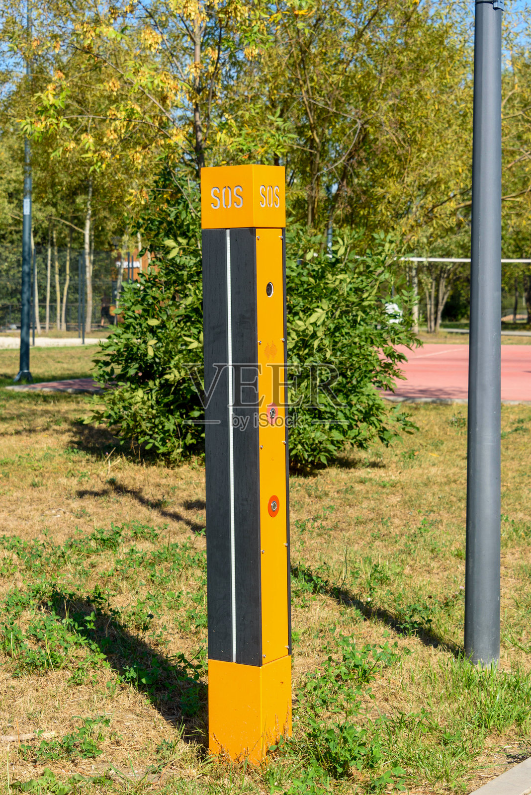 公园里的黄色对讲机，用于柱子上的紧急通讯，附有SOS标志。照片摄影图片