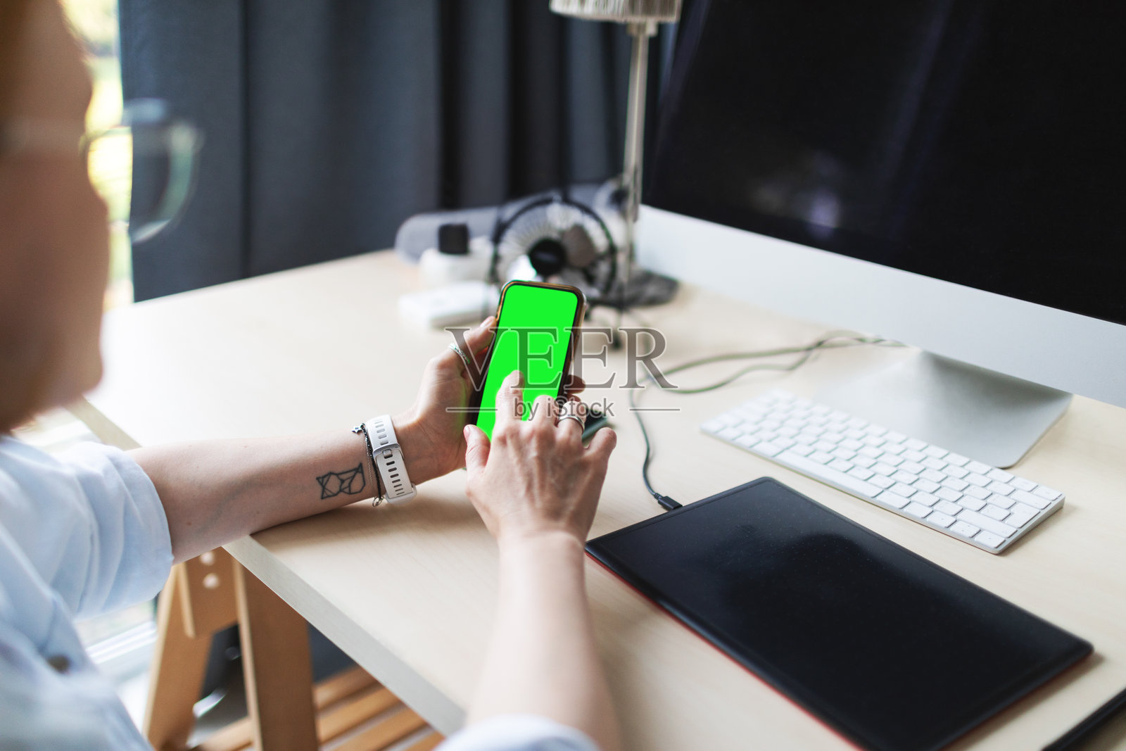 女人手持手机的过肩视角照片摄影图片