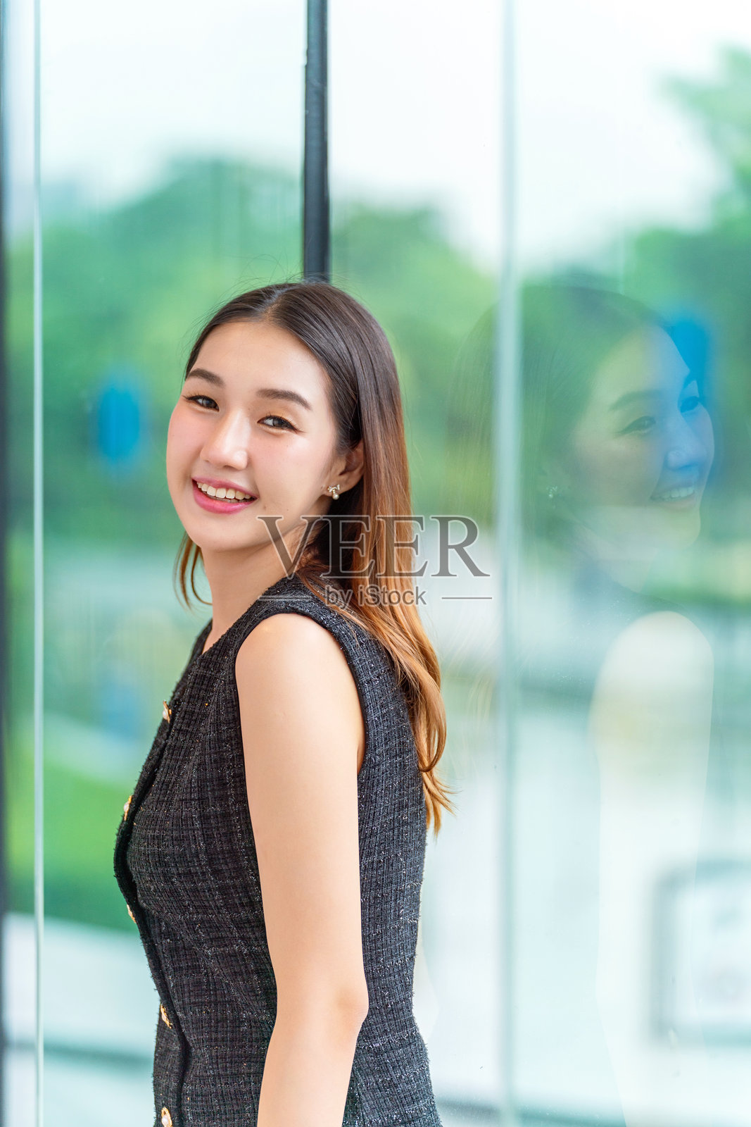 美丽的亚洲女人倚窗看向镜头照片摄影图片