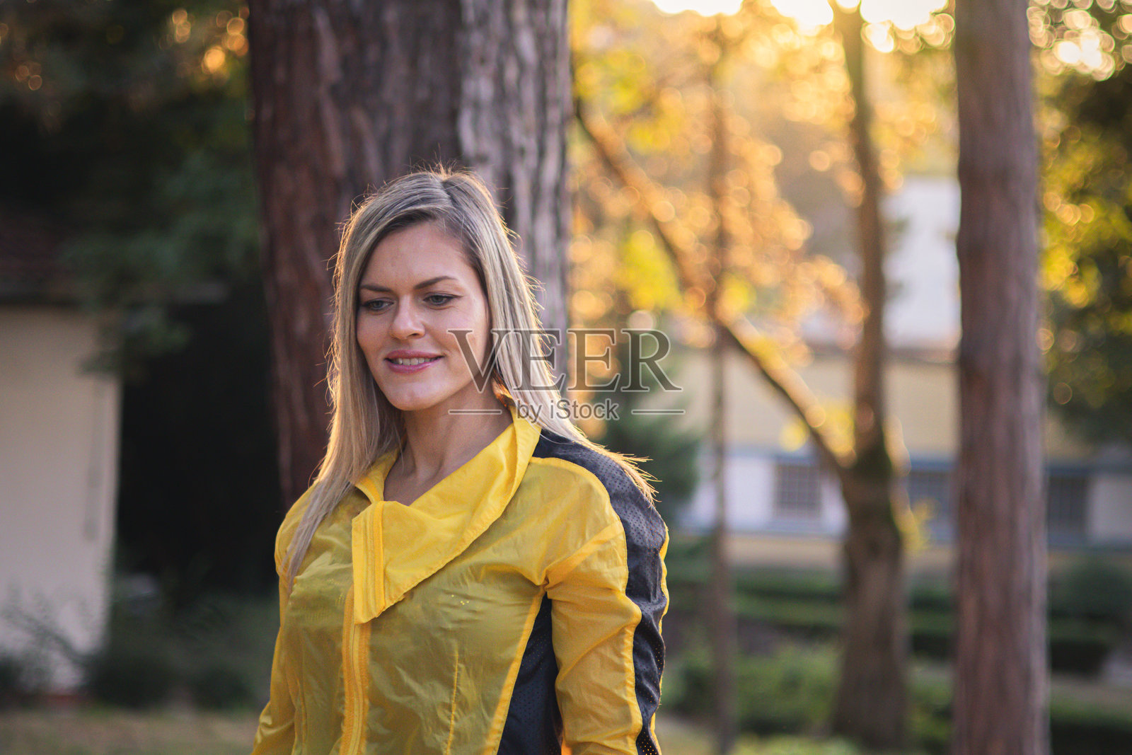 在秋天与自然亲密接触。快乐、微笑的金发女性在日落时分重新与自然连接。照片摄影图片