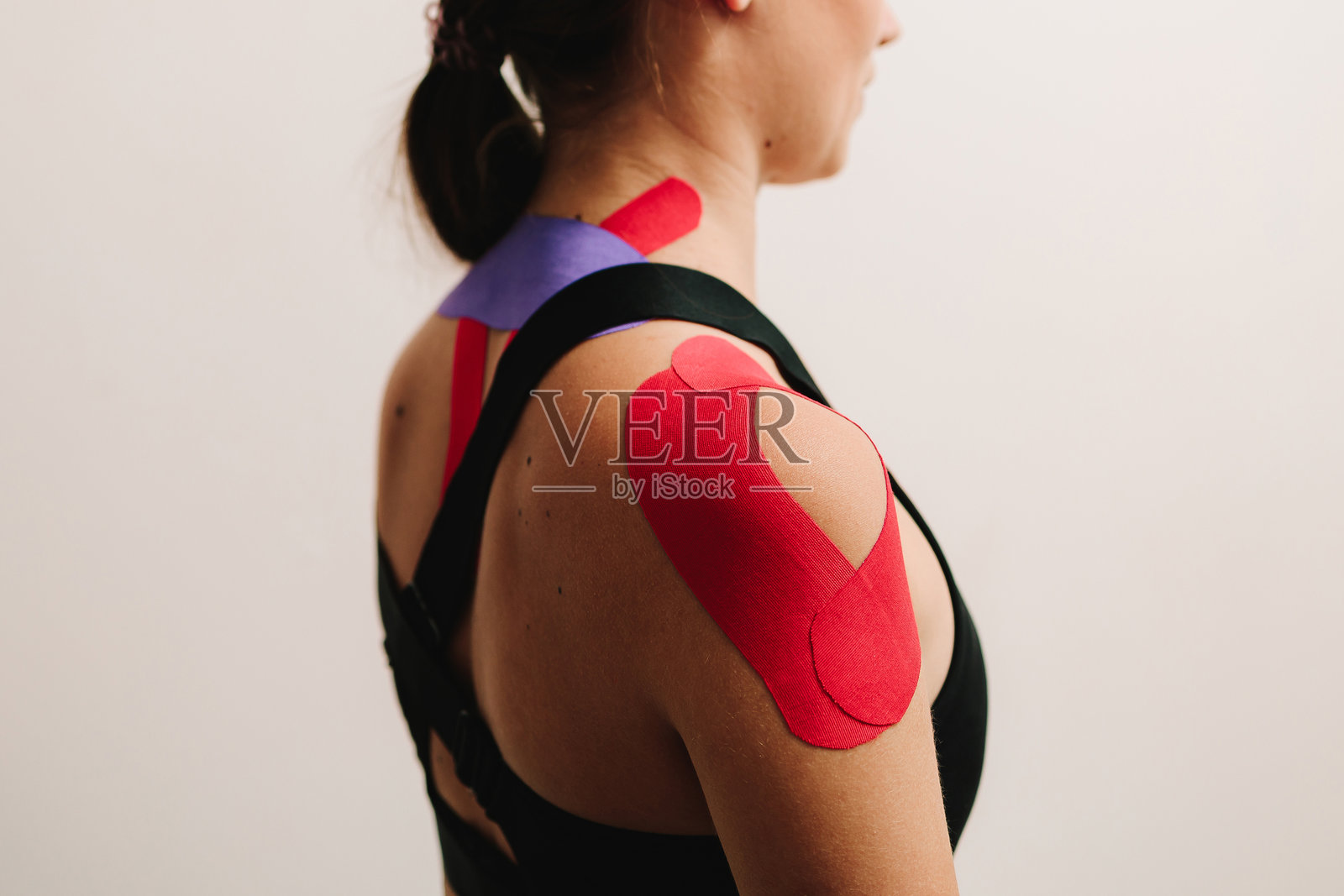 肩部运动学贴布可以促使患者的肌肉收缩。医疗胶带产生运动，改善姿势并有助于稳定关节。照片摄影图片