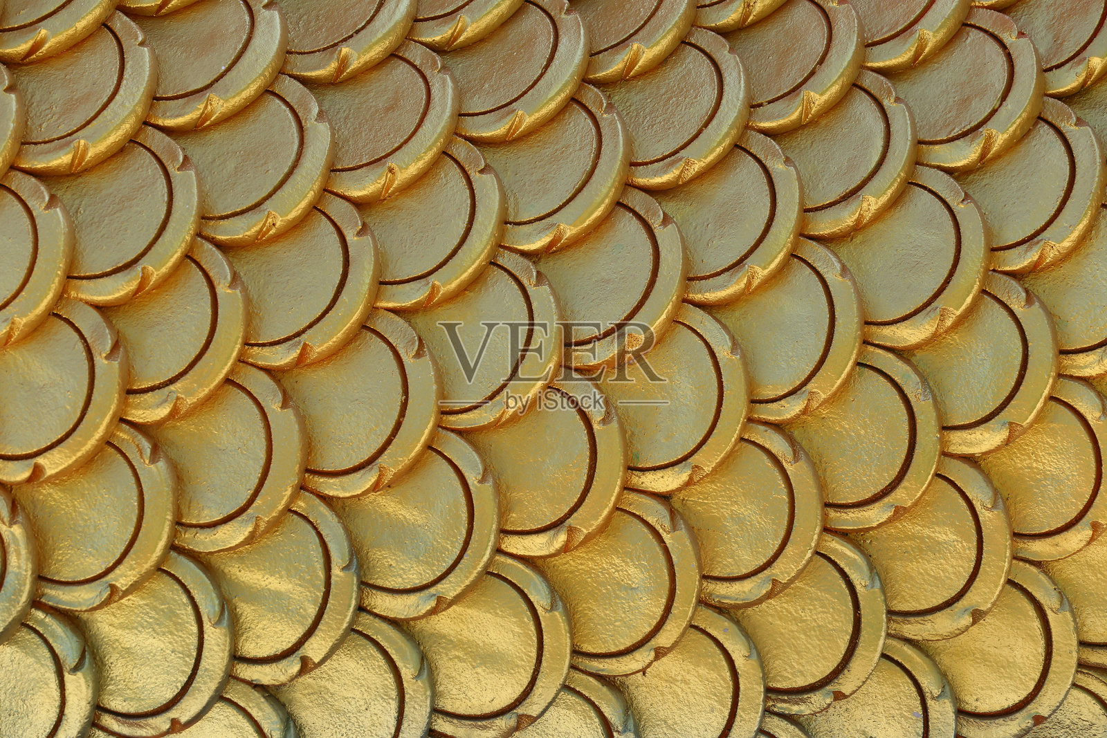 金色的灰泥图案，形状像鱼鳞。照片摄影图片