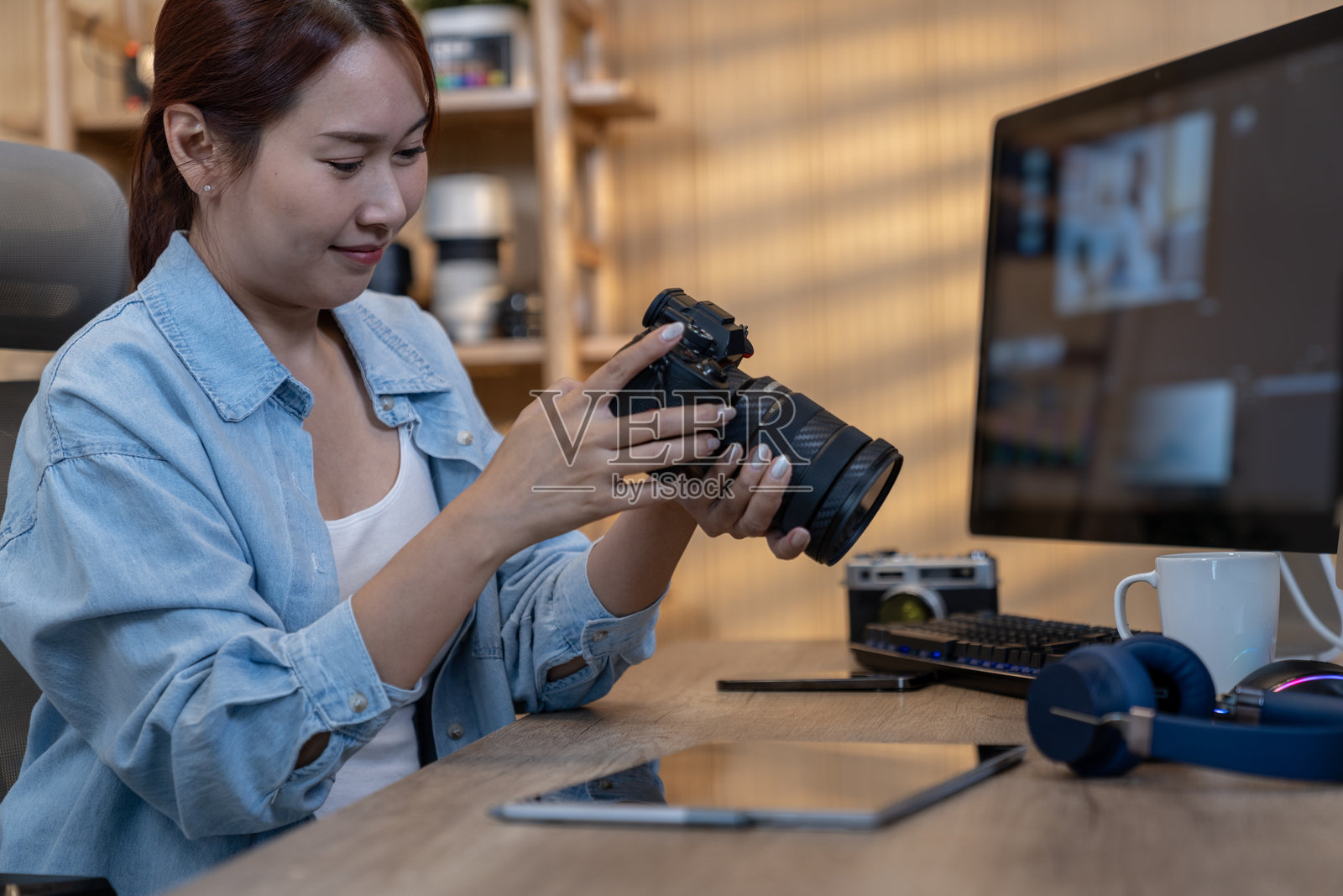 一位女性摄影师在家中使用电脑编辑照片。照片摄影图片