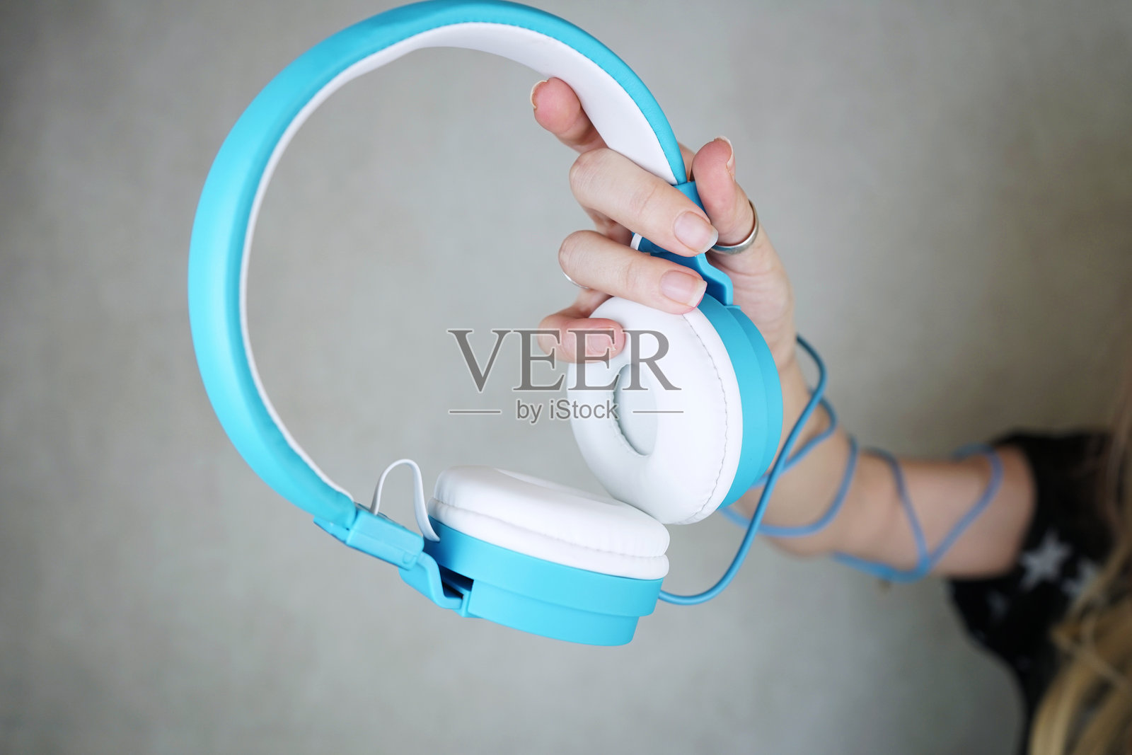 靠近的手握着耳机靠在墙上照片摄影图片