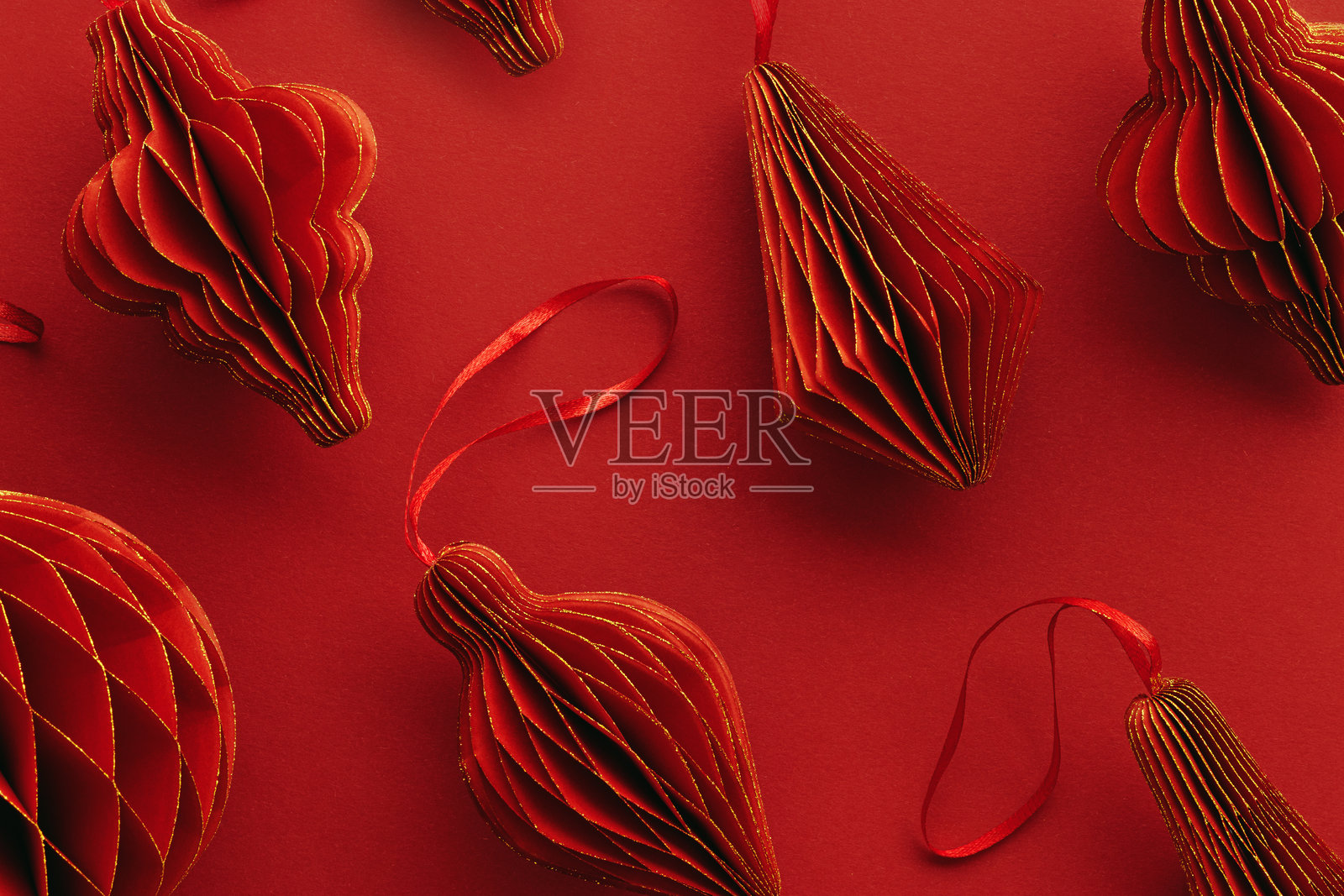 节日红色纸质圣诞装饰品，极简风格线性图案，悬挂的红色手电筒、灯笼、金色闪光球，红色背景上的美学单色，节日假日俯视图照片摄影图片