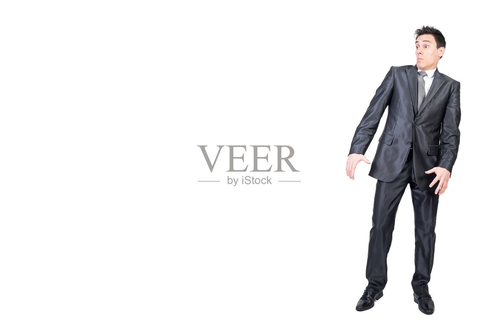 惊讶的年轻商人在白色工作室中侧目而视照片摄影图片