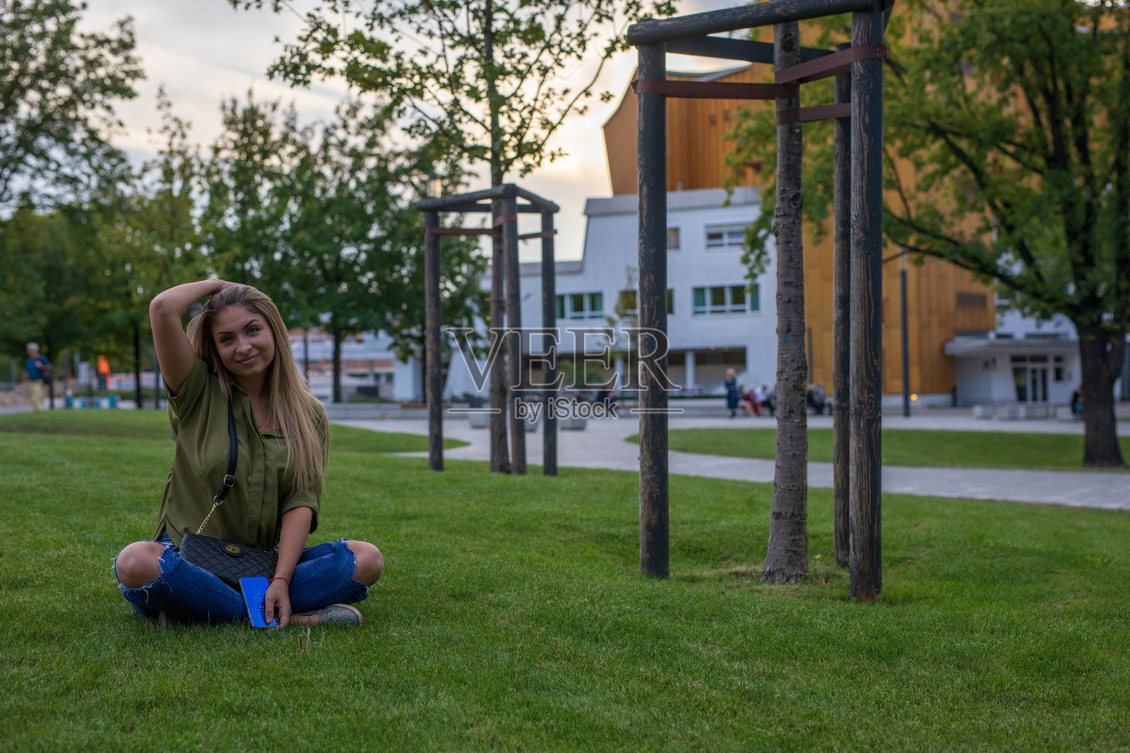 公园里坐在草地上的微笑女性肖像照片摄影图片