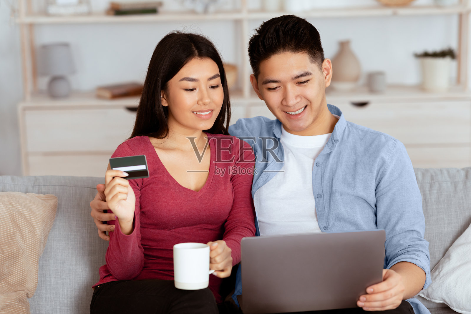 中国情侣使用笔记本电脑和信用卡照片摄影图片