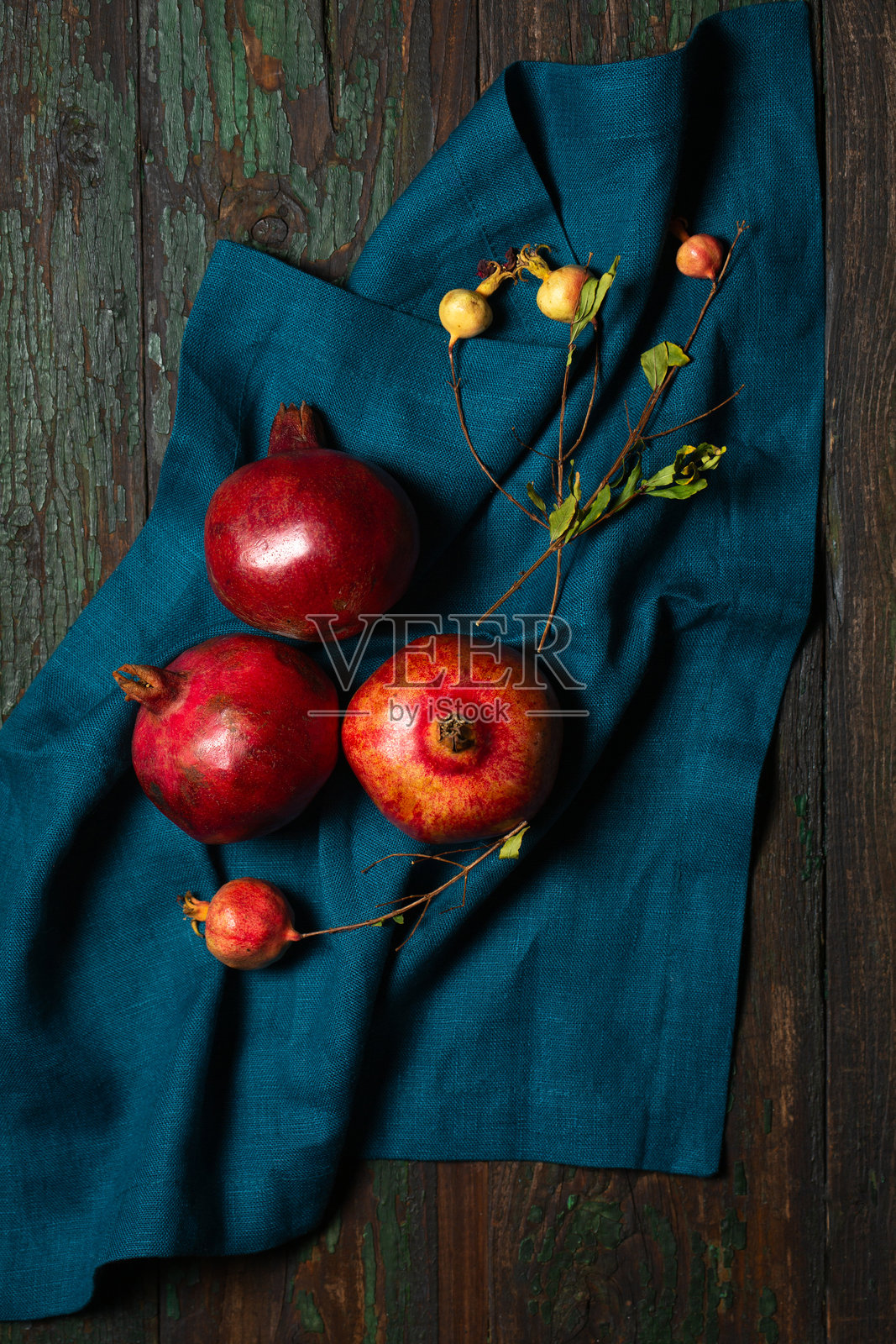 成熟的红石榴放在木桌上的亚麻餐巾上照片摄影图片