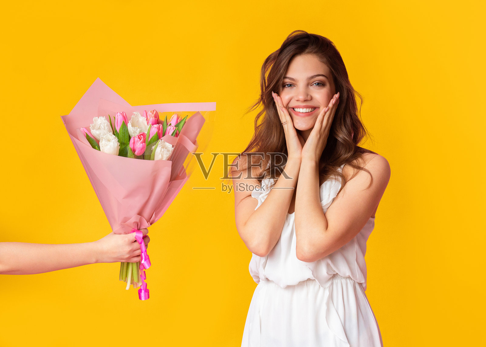 兴奋的年轻女性穿着裙子，收到一束郁金香作为礼物照片摄影图片