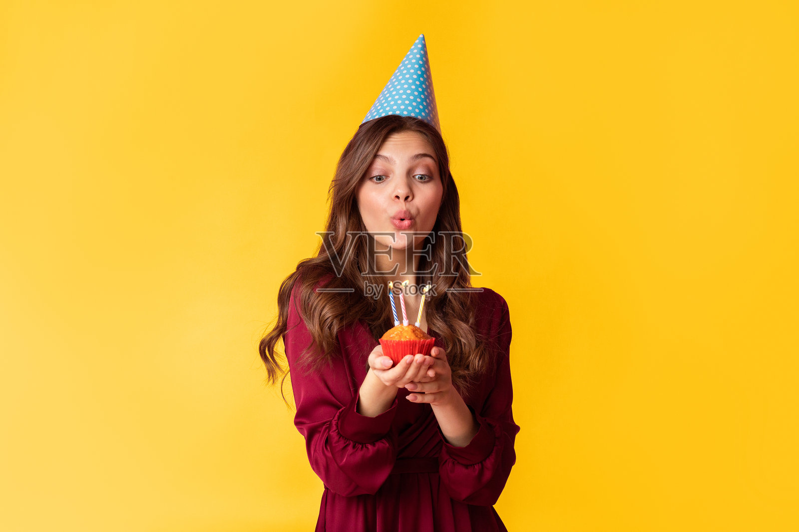 美丽的女士在白色背景下为生日蛋糕上的蜡烛吹气照片摄影图片