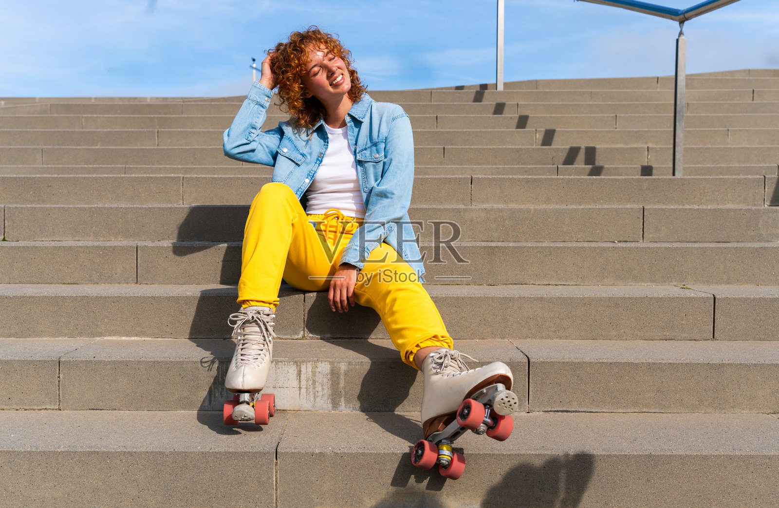 美丽的红发年轻女性在户外穿着滑轮溜冰鞋享受乐趣照片摄影图片