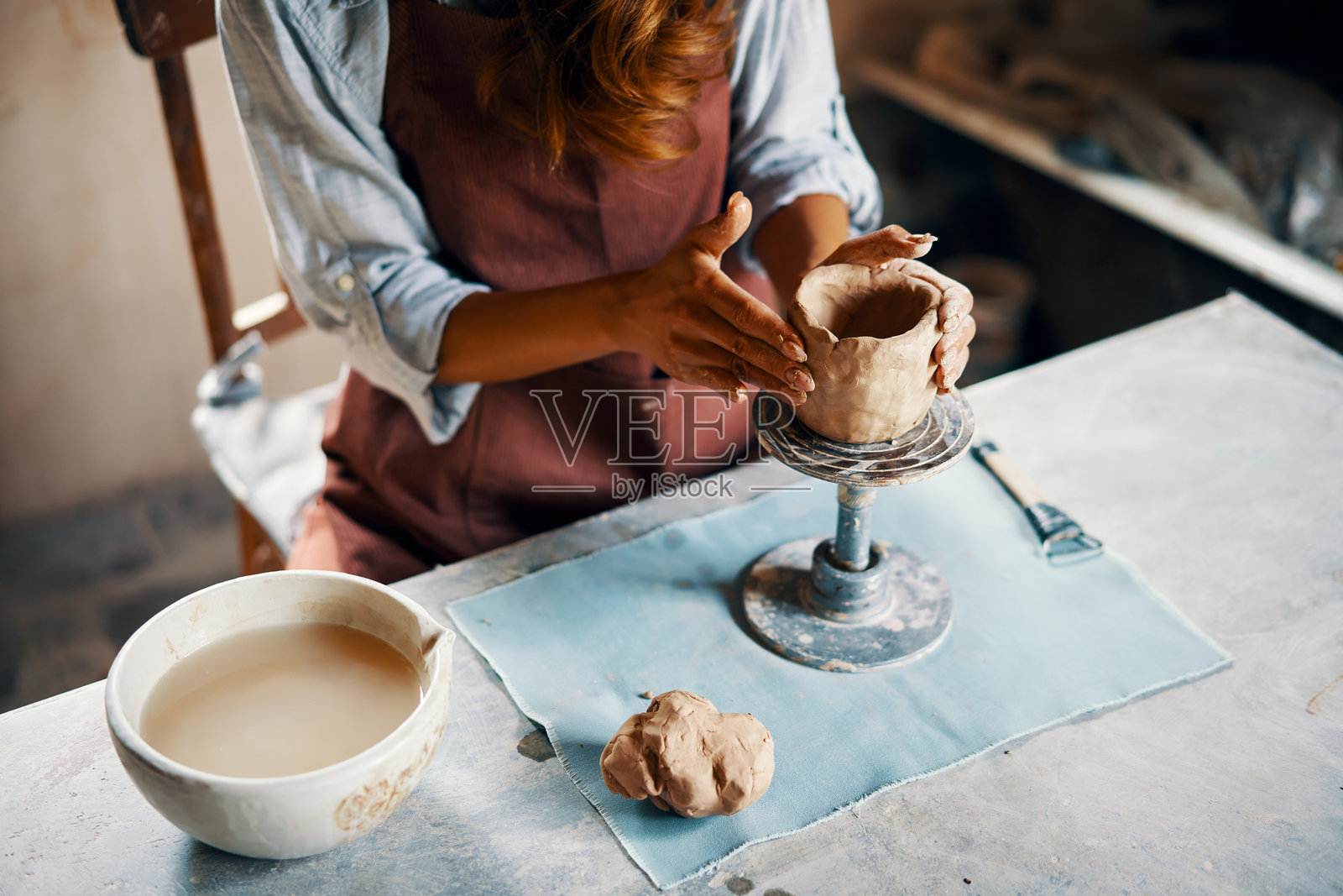 女性艺术家在她的创意工作室用陶土雕刻工艺品照片摄影图片