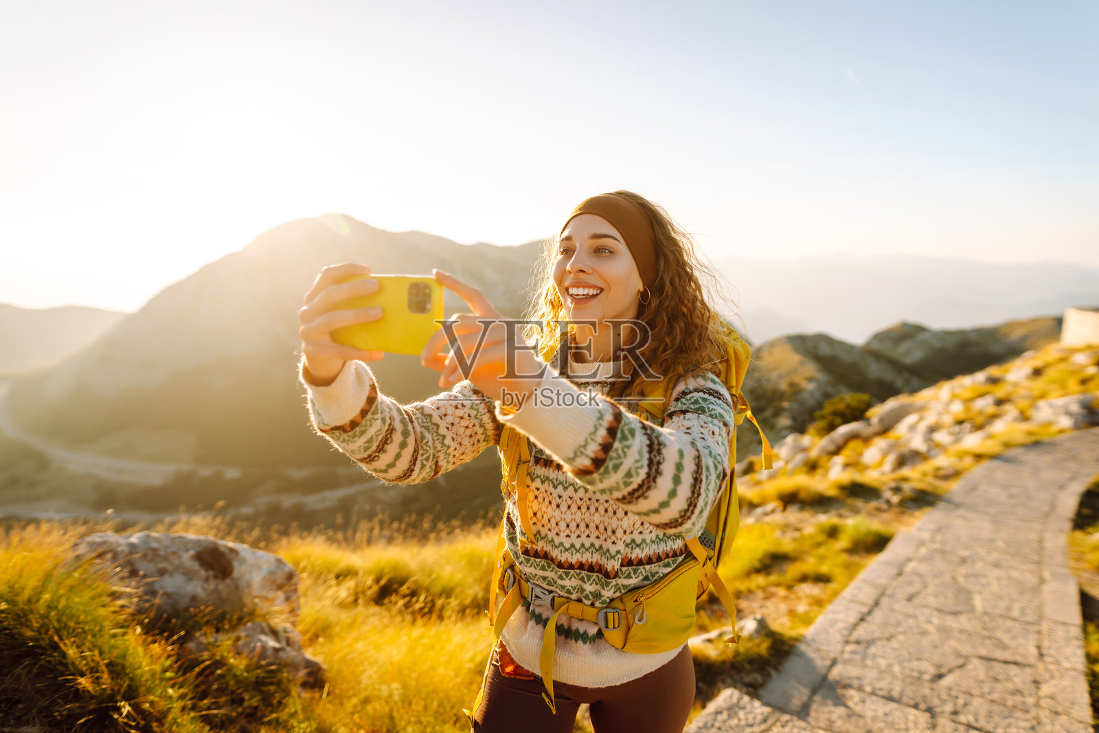 捕捉回忆。年轻女性在尼戈什陵墓用手机拍照。照片摄影图片