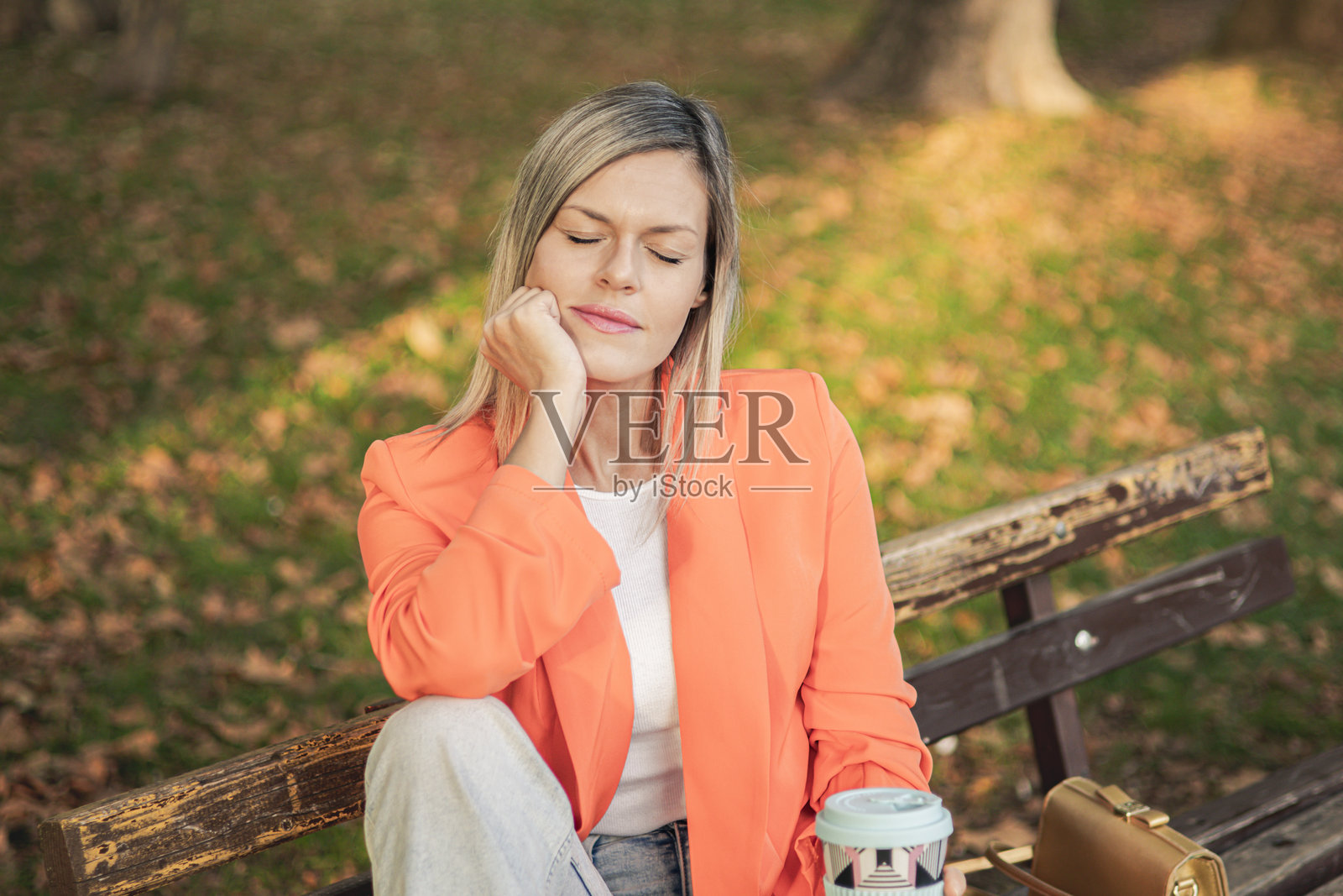 通勤时冥想。美丽的女商人在公园里穿着商务服装，享受工作后回家路上的宁静冥想时刻。城市公园的咖啡休息时间进行减压技巧。照片摄影图片