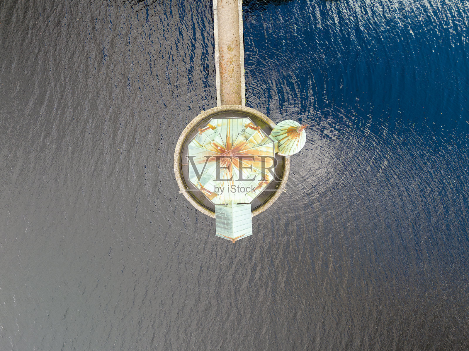 空中俯瞰圆形建筑与陆地通过人行天桥相连照片摄影图片