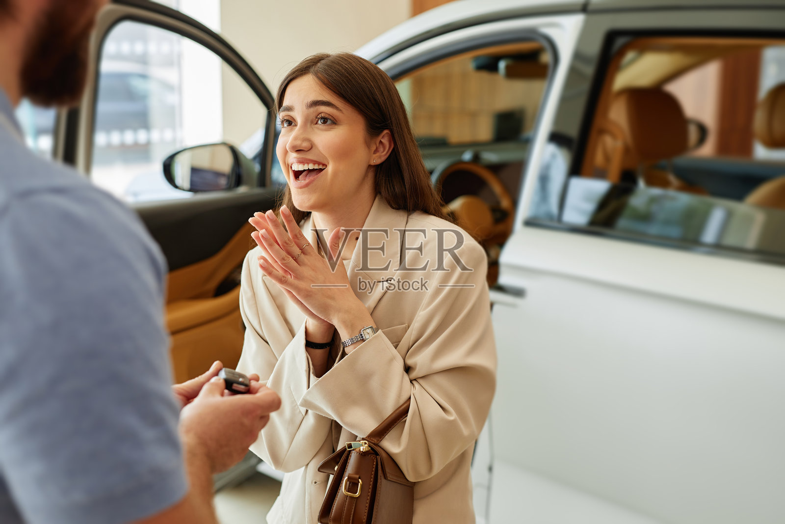 惊喜微笑的女人从男朋友那里收到汽车钥匙作为礼物照片摄影图片