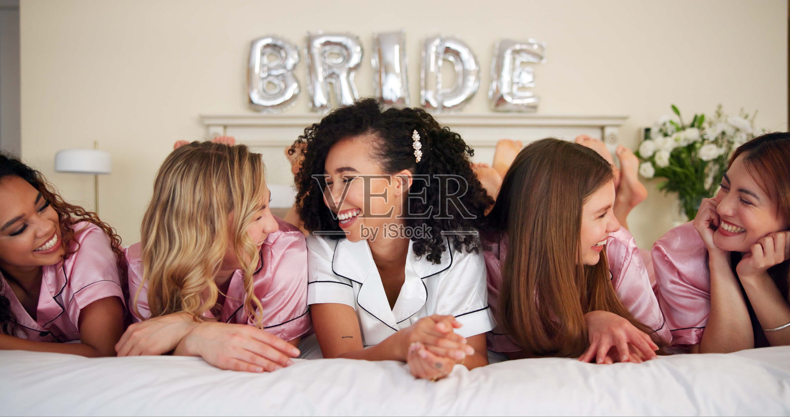 快乐的女性在卧室庆祝婚姻公告，举行婚礼派对和订婚支持。微笑的新娘和朋友们在家中享受承诺活动的惊喜、好消息和亲密时光。照片摄影图片