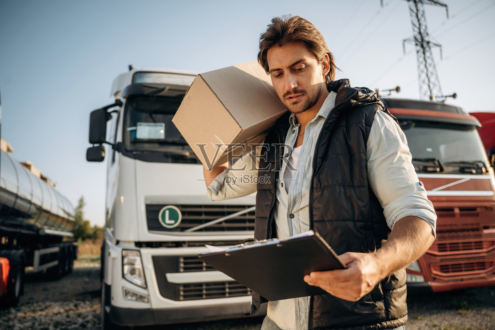 运输构思，旁边有箱子。卡车司机在户外靠近运输工具。照片摄影图片