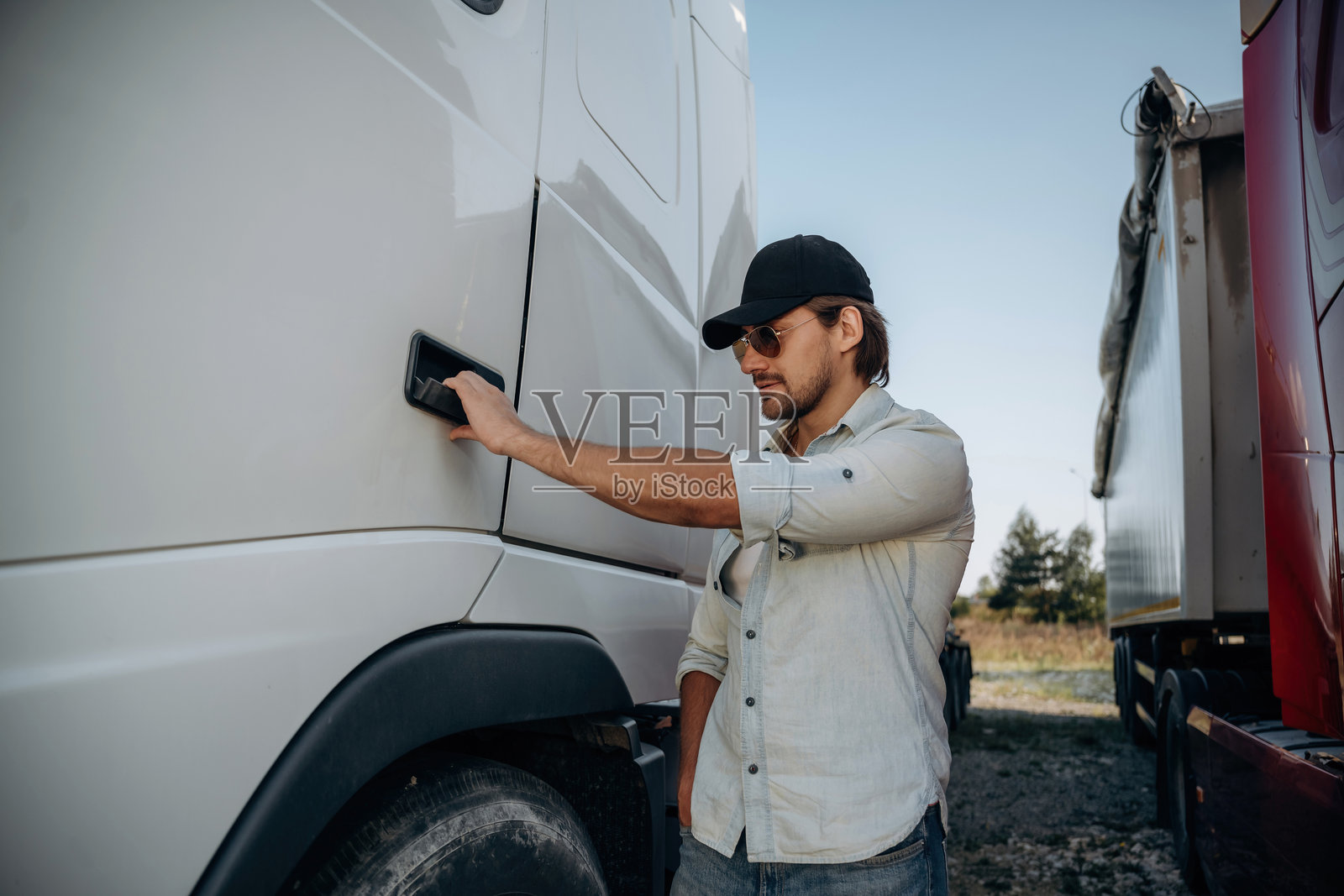 打开门。卡车司机在户外靠近运输车辆。照片摄影图片