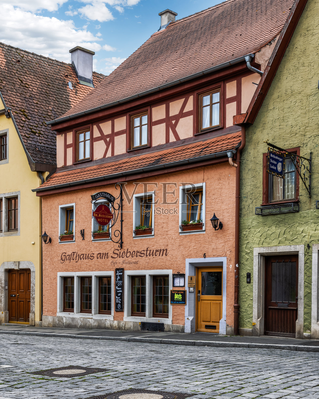 白天在鹅卵石街道上的阿姆西贝斯图尔姆酒店的五彩斑斓的中世纪建筑照片摄影图片