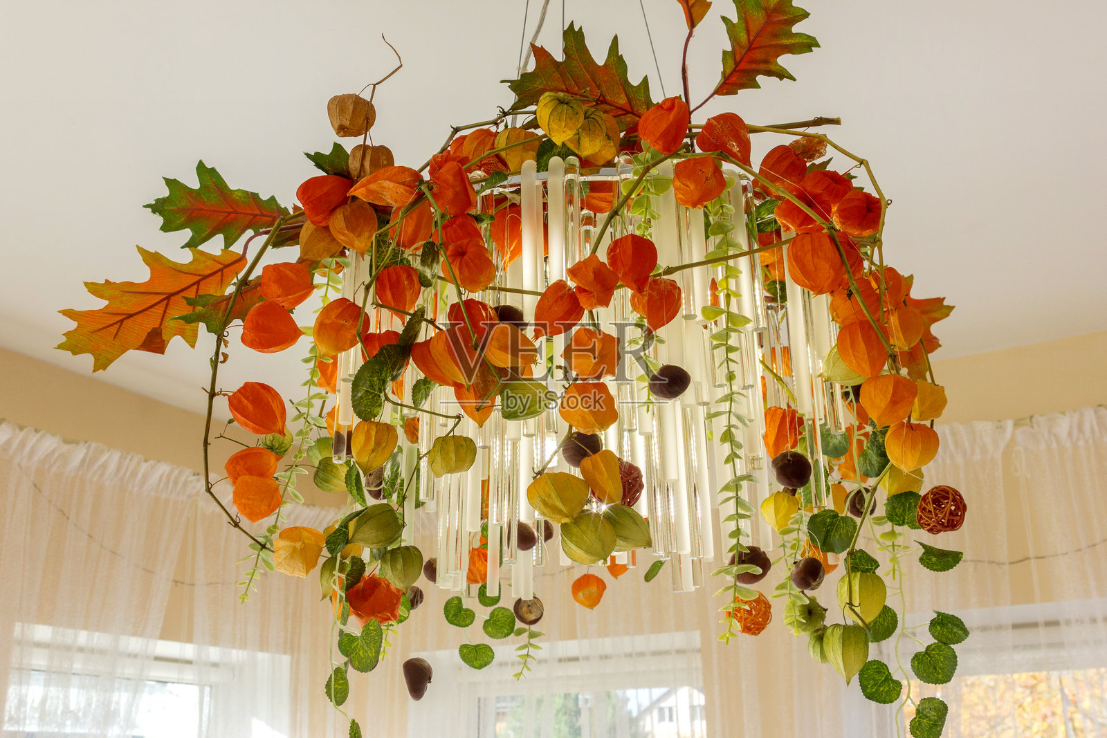 室内装饰有吊灯和灯笼果，布置成万圣节主题。照片摄影图片
