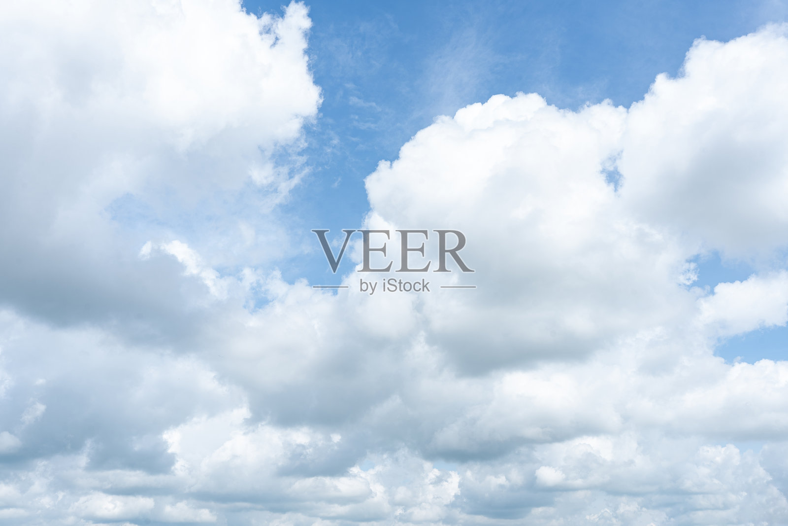 蓬松的积云在明亮的蓝天上漂浮，描绘出一个美丽的夏日。照片摄影图片