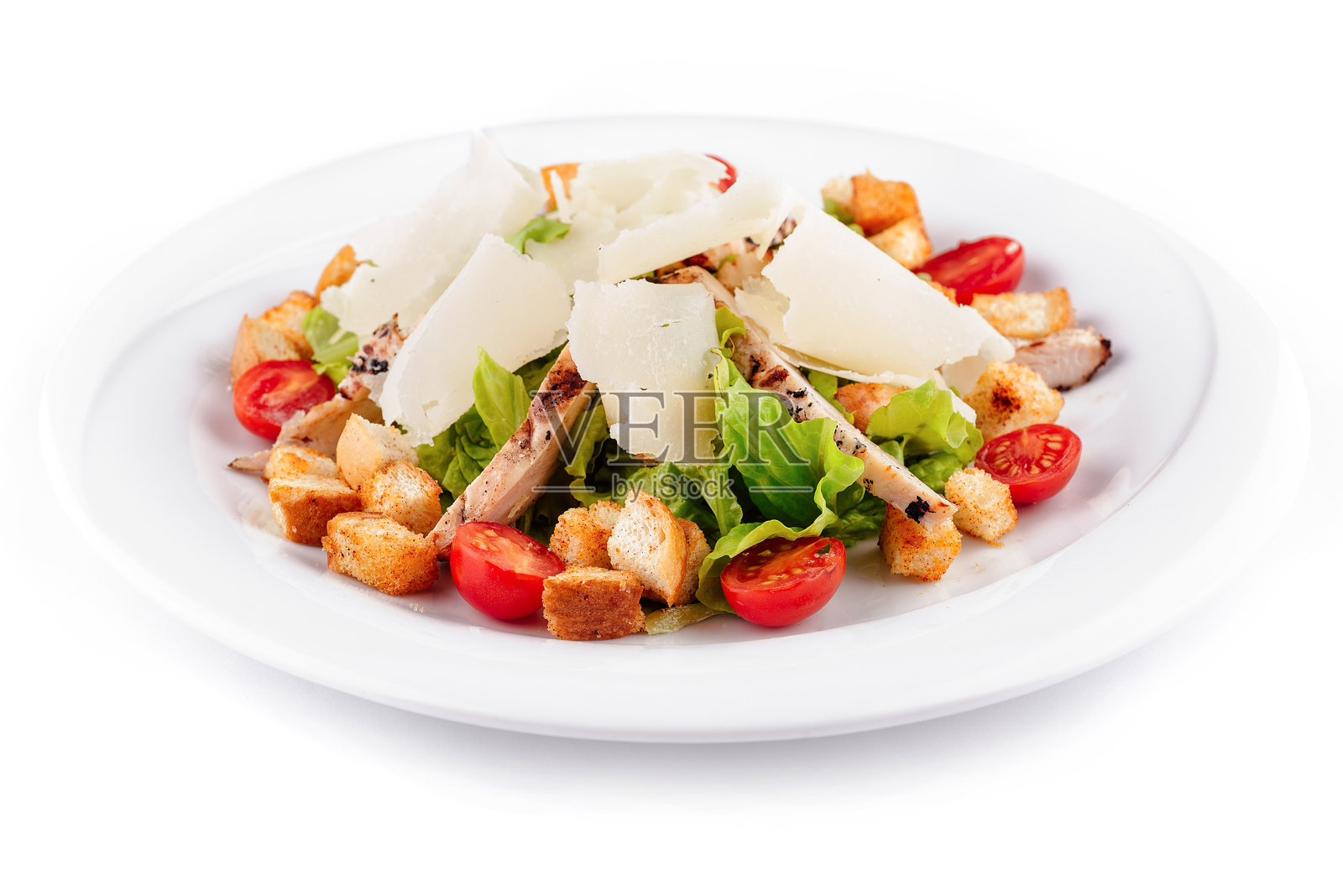 美味的凯撒沙拉配鸡肉，盛在白色盘子里。照片摄影图片