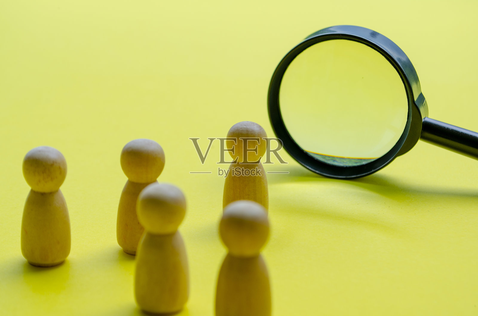 木制人偶站着看放大镜照片摄影图片