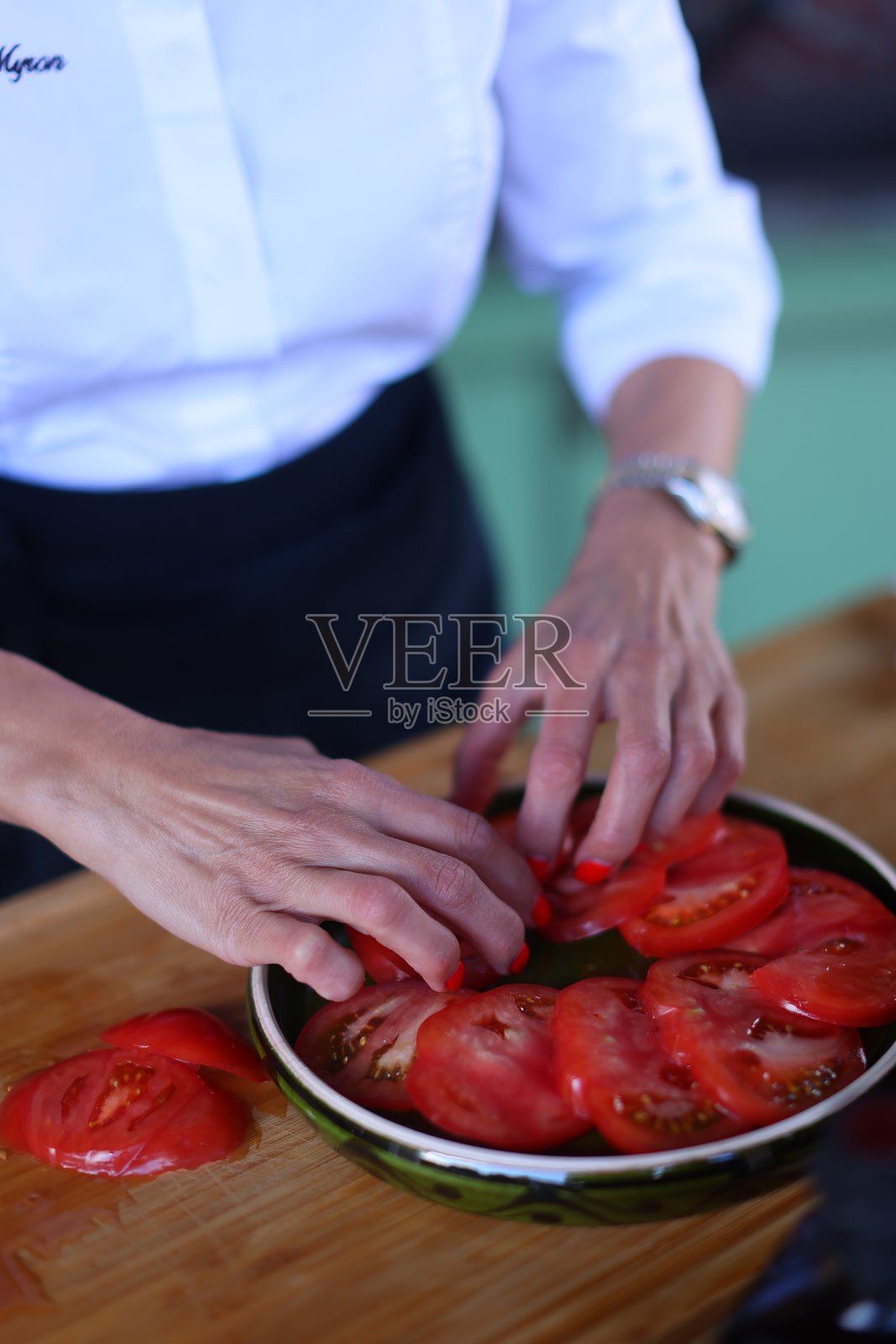 厨师的手拿着刀准备新鲜番茄的食材照片摄影图片