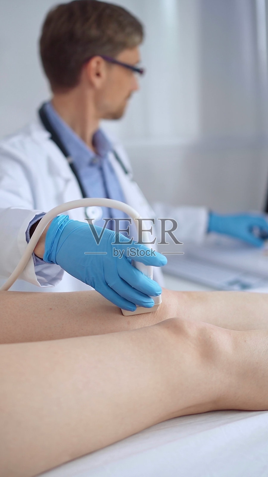 医生用超声设备为女病人检查膝盖照片摄影图片