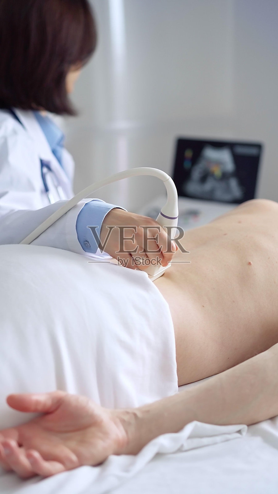 医生为病人进行背部超声检查照片摄影图片